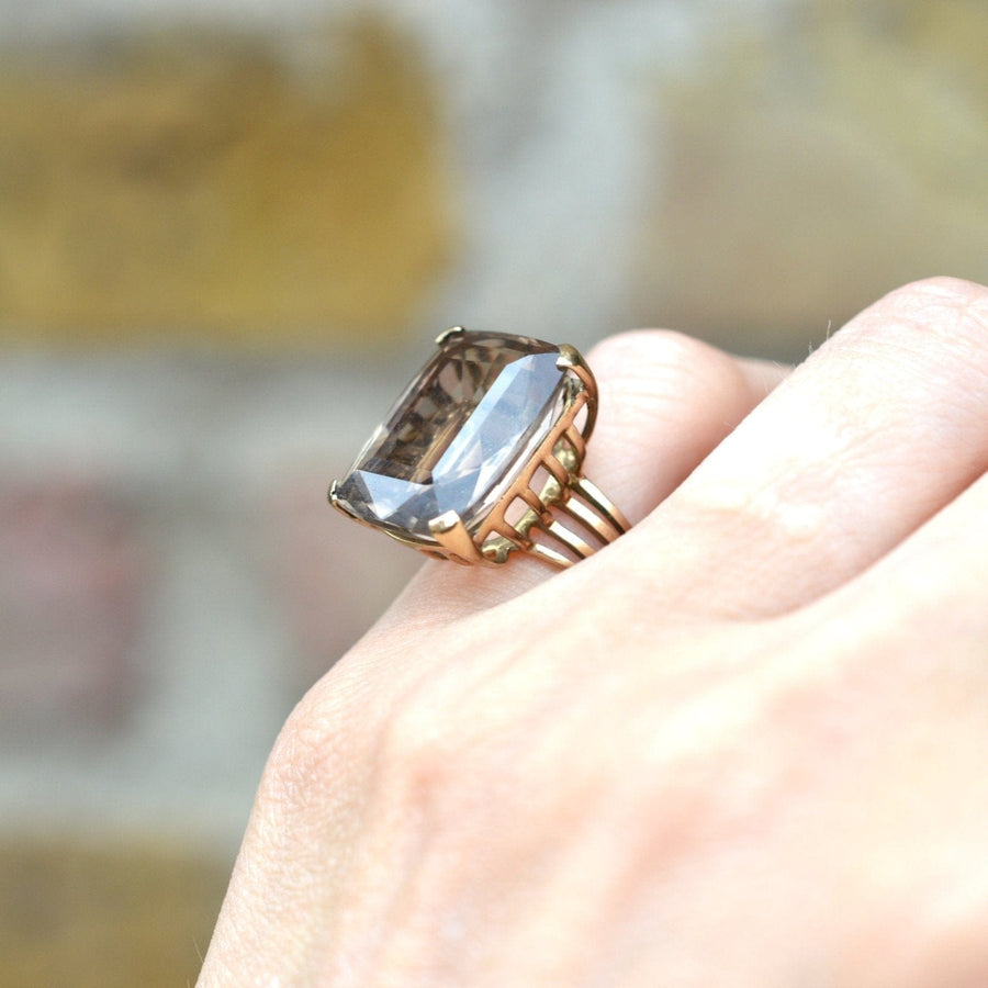Large mid-century 9ct gold smoky quartz cocktail ring on a hand, showcasing its captivating openwork shank design.