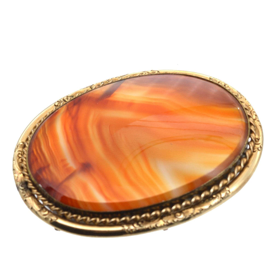 Large Scottish Victorian 9ct gold banded agate brooch with vibrant orange and amber hues.