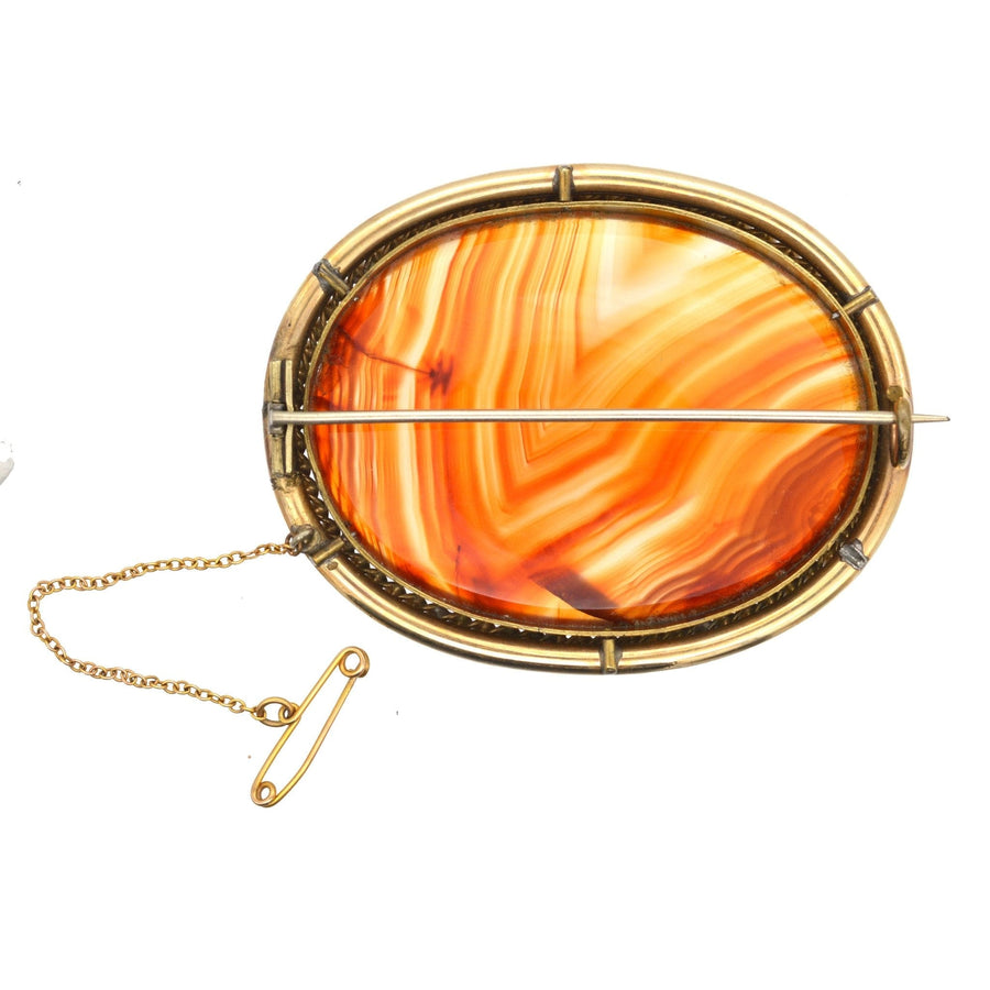 Large Victorian 9ct gold brooch featuring stunning banded agate with vibrant orange hues.