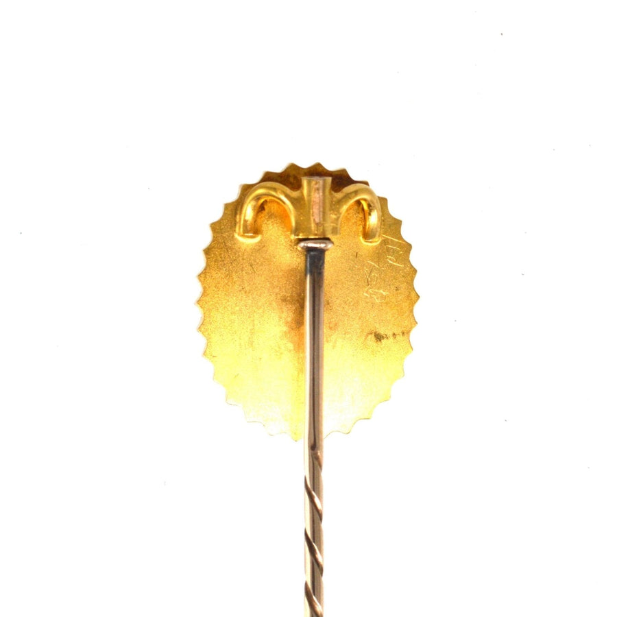 Back view of a Victorian gold tie pin featuring a twisted stem and scalloped edge design.