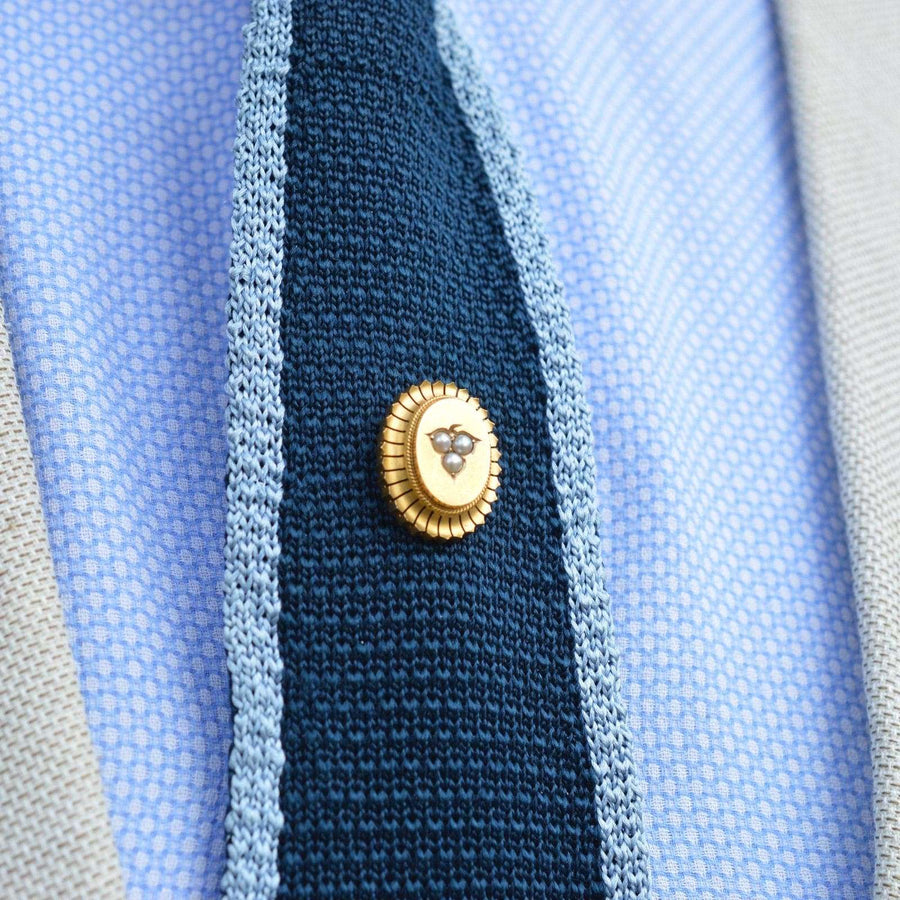 Large Victorian 15ct gold oval tie pin with split pearl leaf motif on a silk tie.