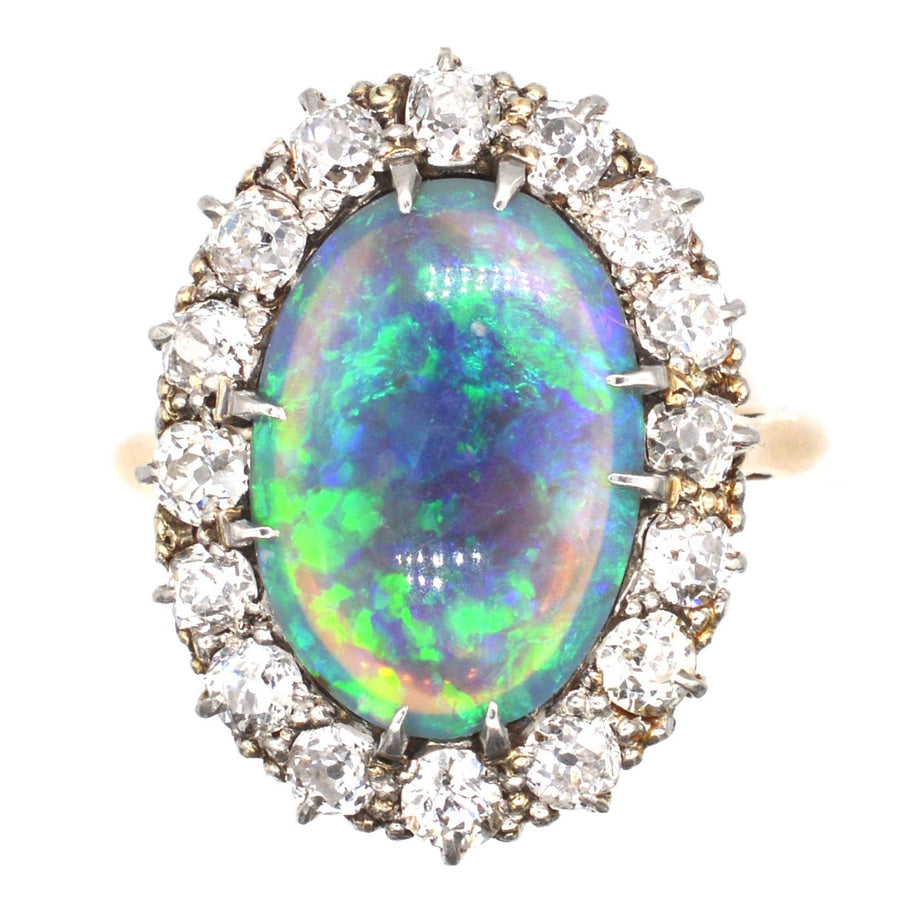 Large Victorian 18ct gold ring featuring a vibrant black opal surrounded by sparkling diamonds.