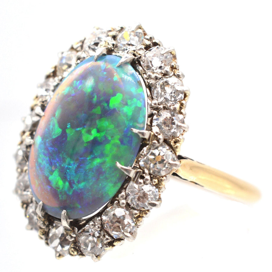 Large Victorian 18ct gold ring featuring a vivid black opal surrounded by sparkling diamonds.