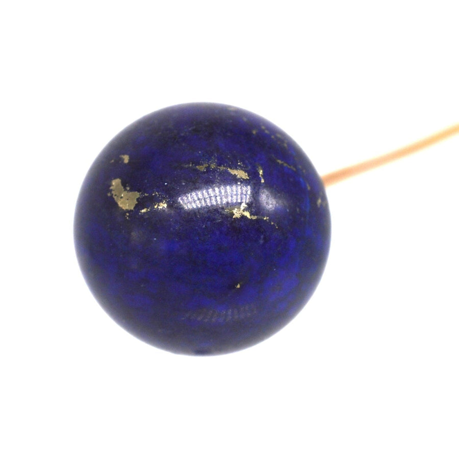 Close-up of a large Victorian 18ct gold tie pin featuring a blue lapis lazuli sphere with gold flecks.