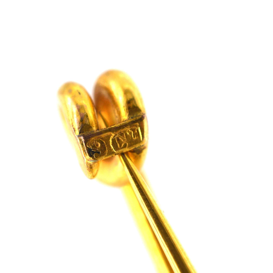 Close-up of a large Victorian 9ct gold stock pin brooch, showing intricate details and hallmark.