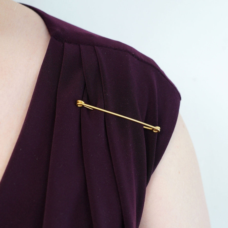 Large Victorian 9ct Gold stock pin brooch clasped on a purple fabric, showcasing vintage fashion and practical utility.