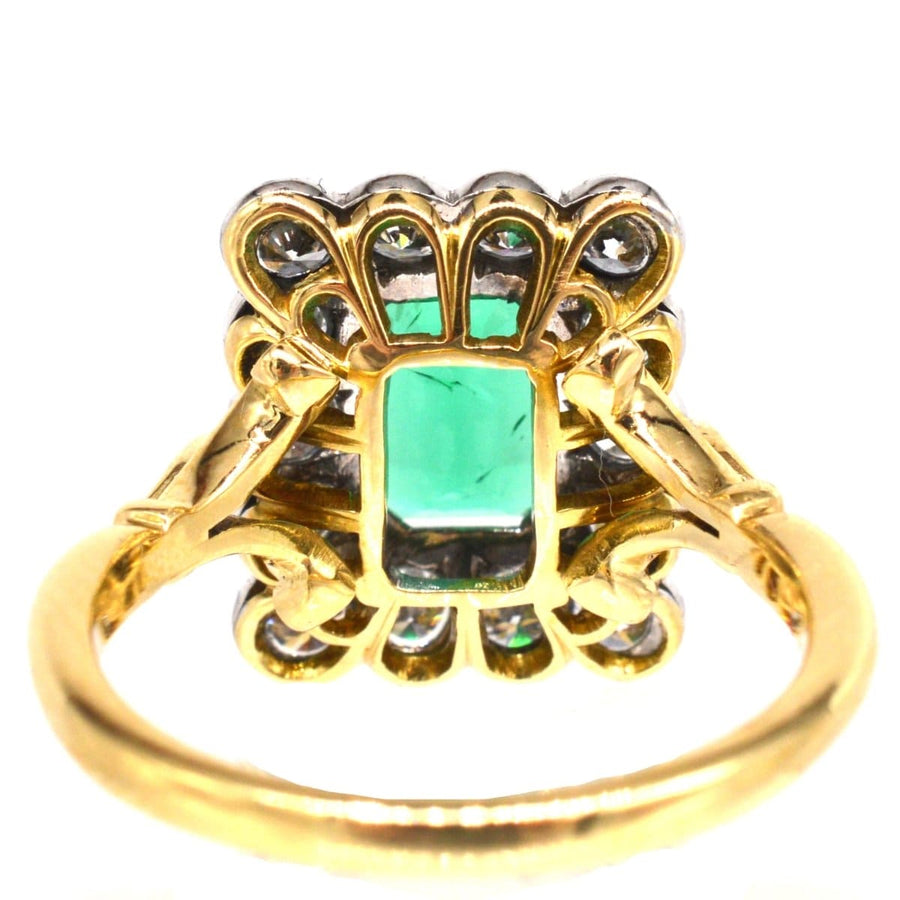 Large vintage rectangular cluster ring featuring a natural emerald and diamonds in gold and platinum.