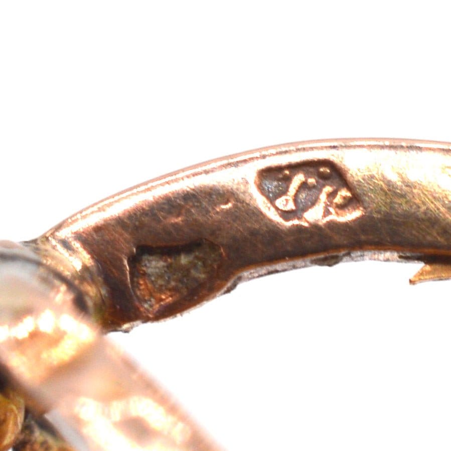 Close-up of 18ct gold hallmark on French mini hoop earrings, featuring horse head symbol.