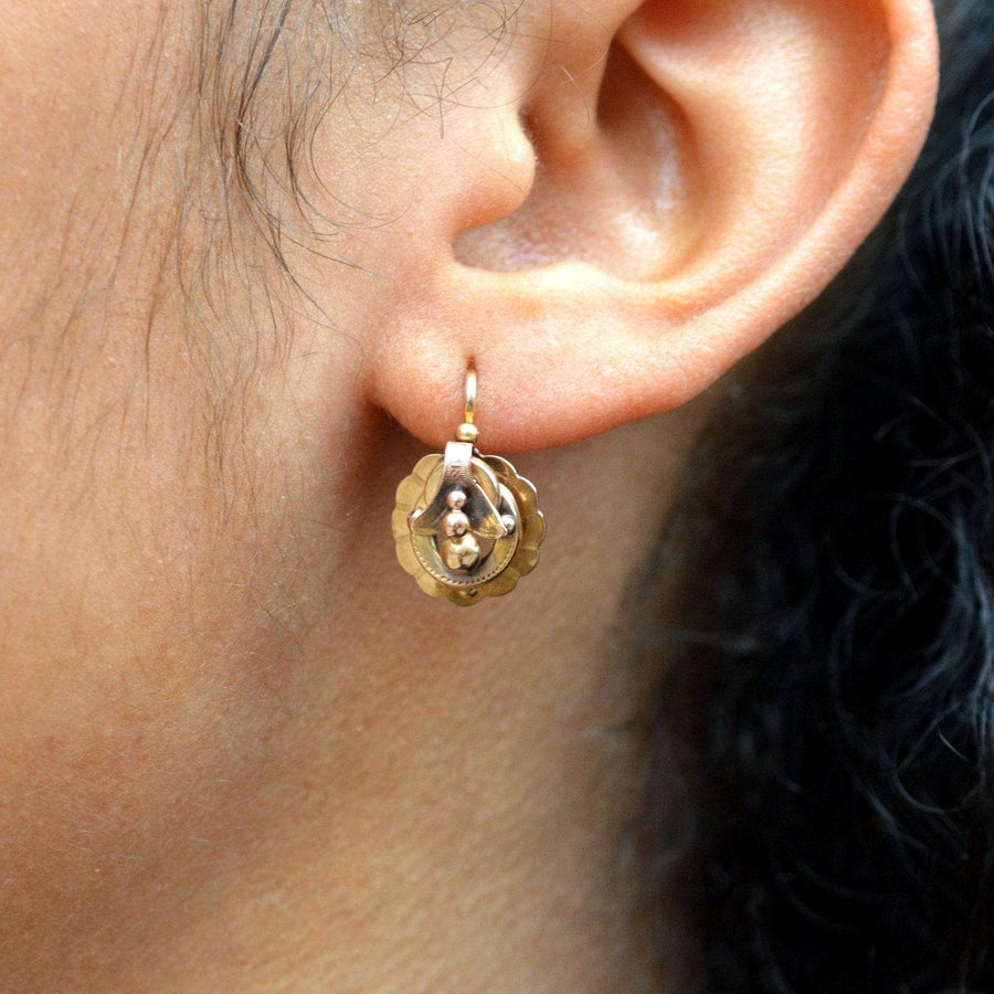 Close-up of 19th century 18ct gold mini hoop Dormeuses earrings worn on an earlobe, showcasing unique design.