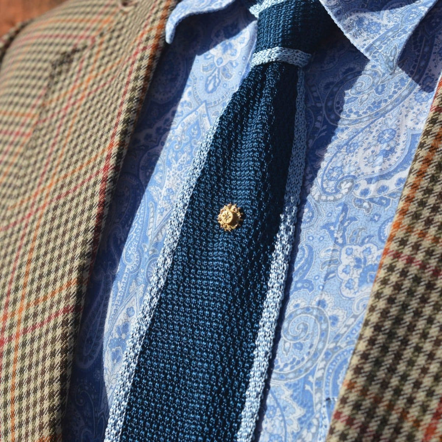 Late Victorian 15ct gold star tie pin on a textured navy tie, styled with a patterned shirt and checked blazer.