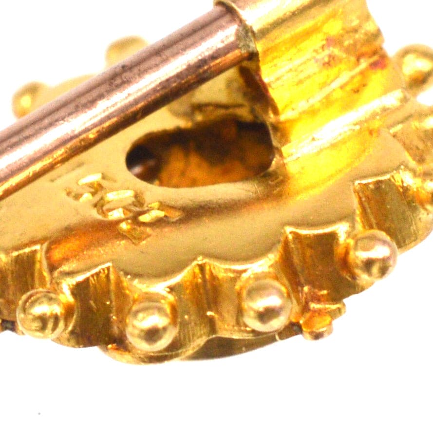 Close-up of a Late Victorian 15ct gold star tie pin with intricate detailing and clasp mechanism.