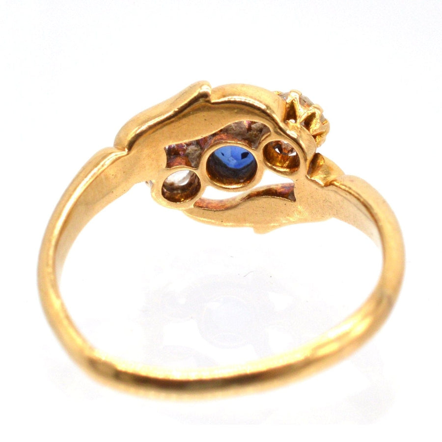 Late Victorian 18ct gold crossover ring featuring sapphire and diamond, intricately carved design, made in 1900.