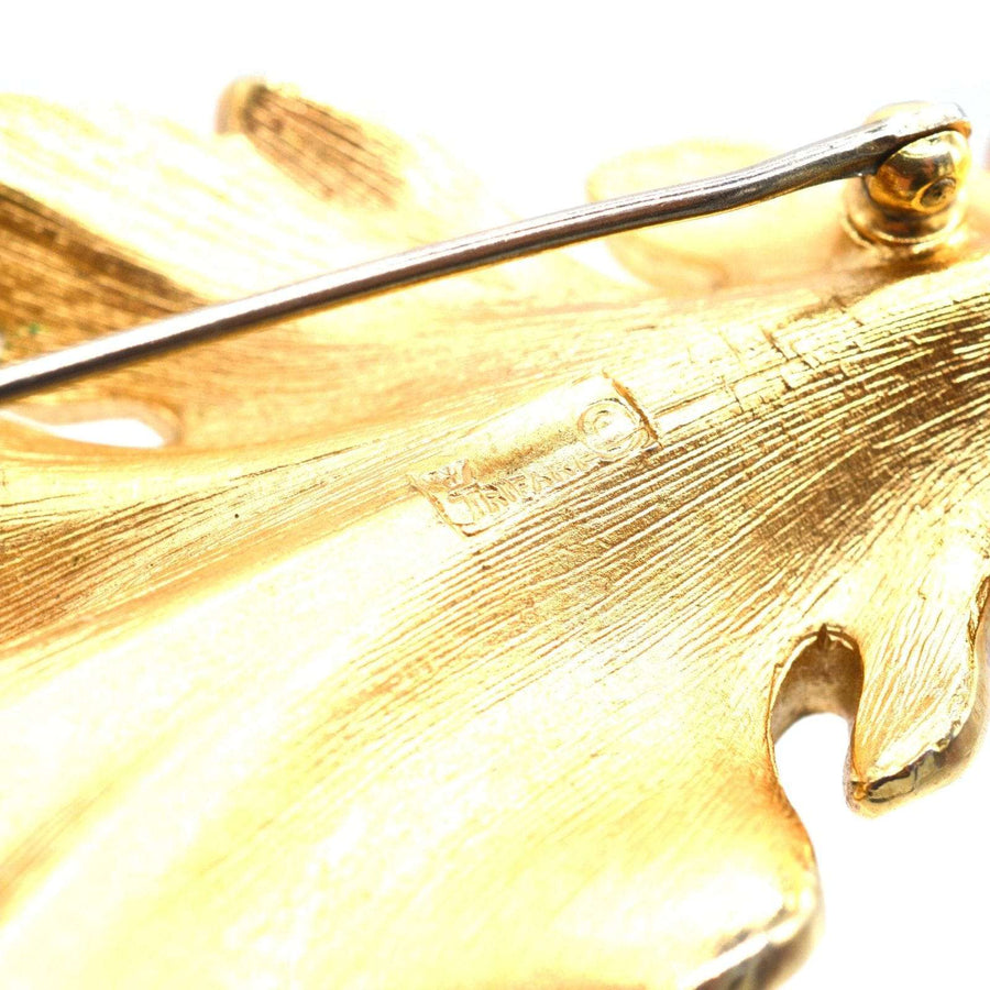 Close-up of Mid Century Trifari gilt metal leaf brooch showcasing intricate detailing and signature.