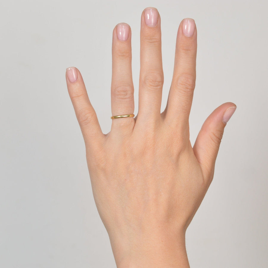 Elegant 18ct gold plain wedding ring displayed on a hand, perfect for stacking or as a simple wedding band.