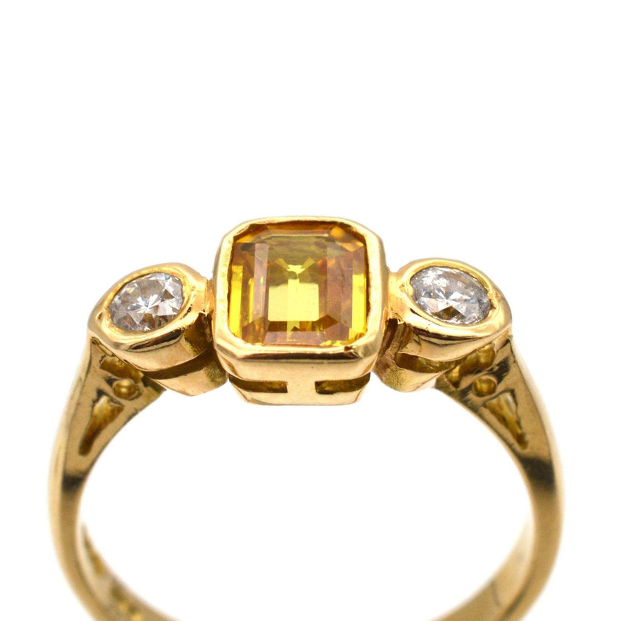 Modern 18ct gold ring featuring a yellow sapphire centerpiece and two white diamonds, ideal for engagement.