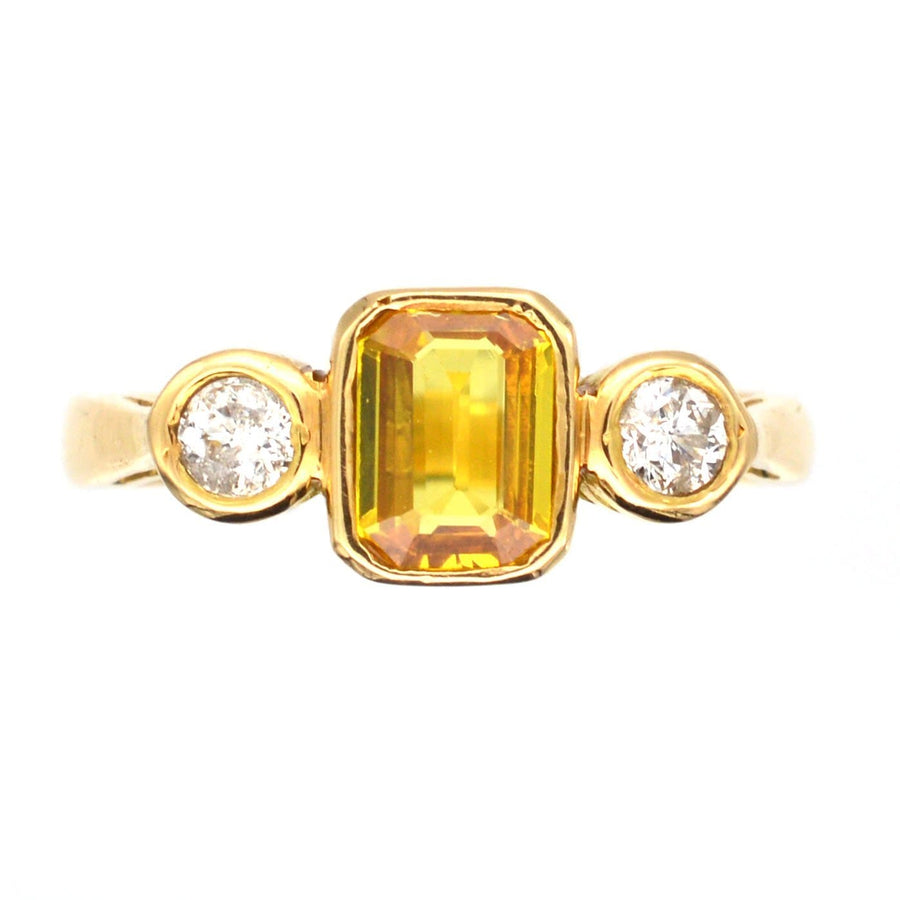Modern 18ct gold ring featuring a yellow sapphire center stone flanked by two white diamonds.