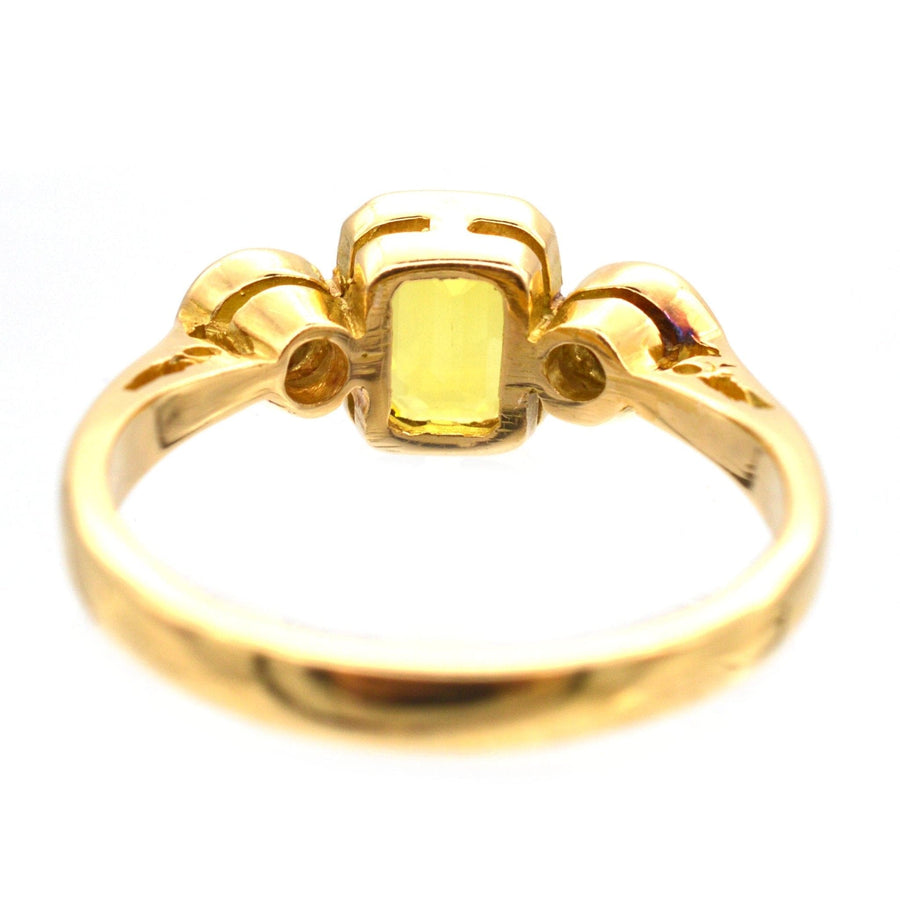 Modern 18ct gold ring featuring a golden yellow sapphire and two white diamonds.
