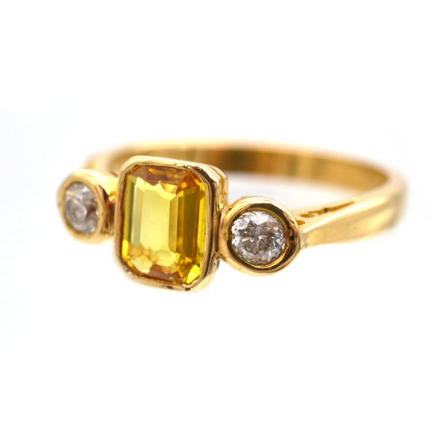 Modern 18ct gold ring with a yellow sapphire and two white diamonds, perfect for engagement.