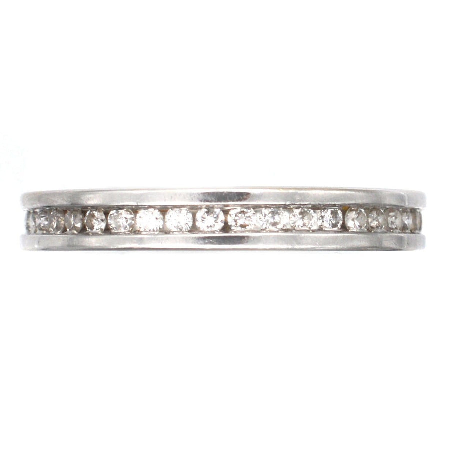 Modern 18ct white gold diamond eternity ring with channel setting, showcasing sparkling diamonds around the band.