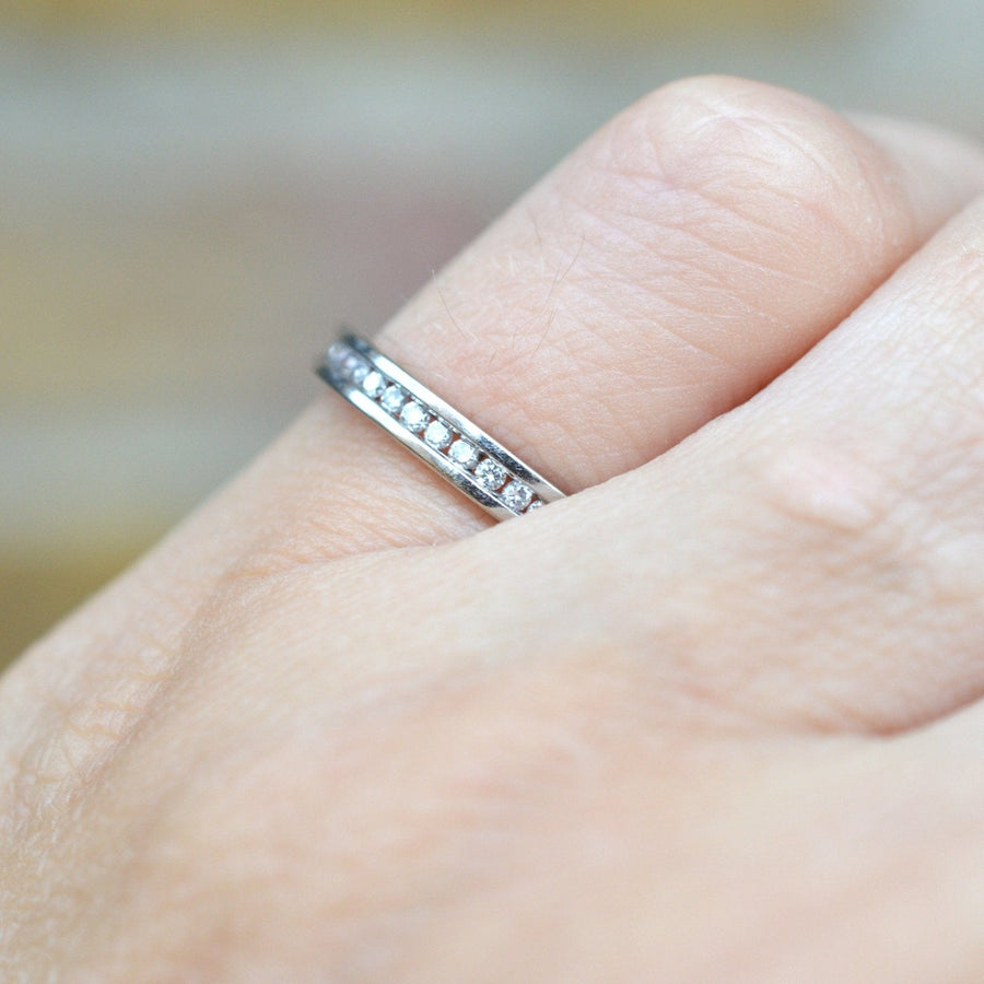 Elegant 18ct white gold diamond channel setting eternity ring on a hand, showcasing the exquisite band design.
