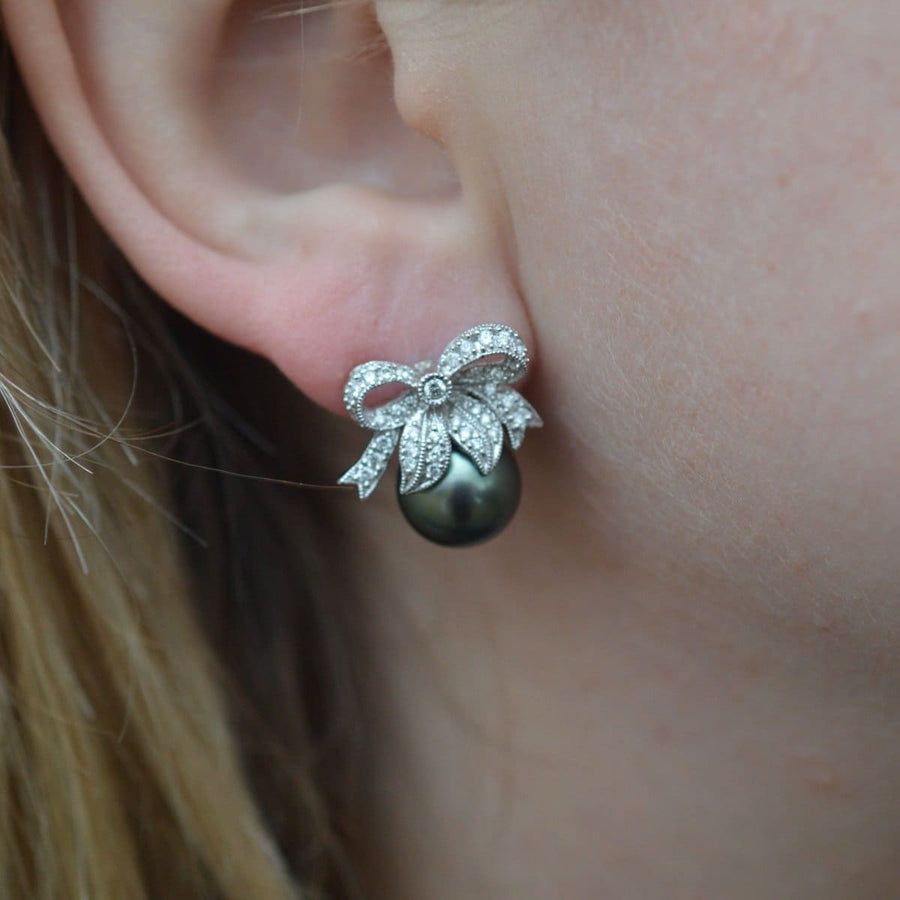 Modern diamond bow and Tahitian black pearl stud earrings, showcasing elegance and timeless style.