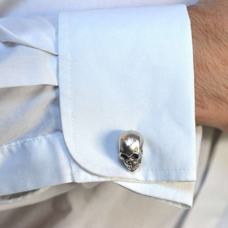 Modern sterling silver skull cufflink on a white shirt cuff, showcasing rock n roll style and intricate detail.