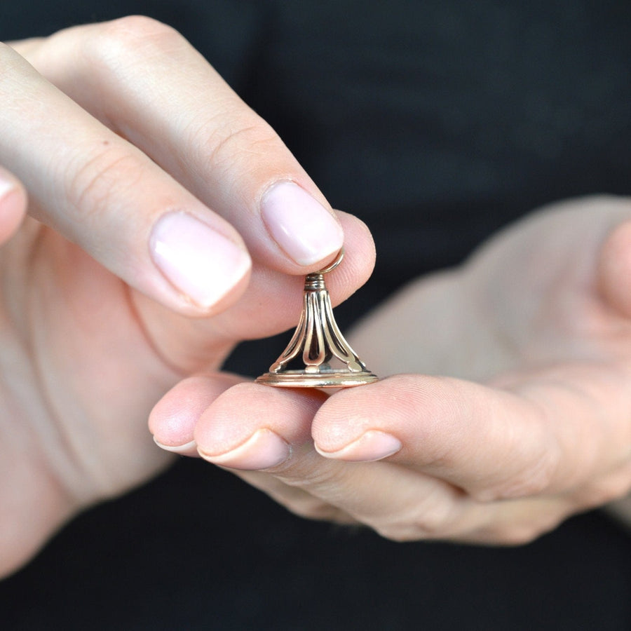 Person holding a delicate 9ct gold Regency seal with an openwork design.