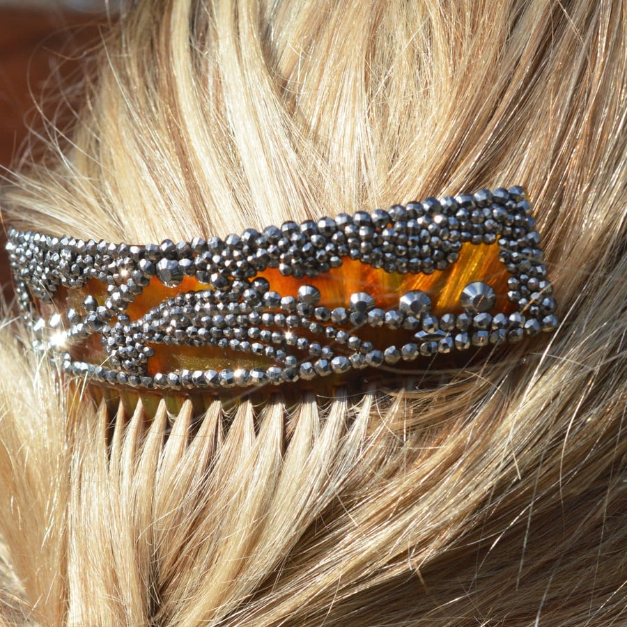 Regency tortoiseshell and cut steel hair comb featuring a shooting star design, worn in a lady's hair.