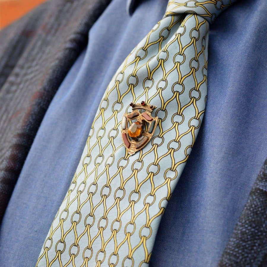 Scottish 9ct gold Luckenbooth Shield tie pin featuring a Cairngorm Citrine on a patterned tie.