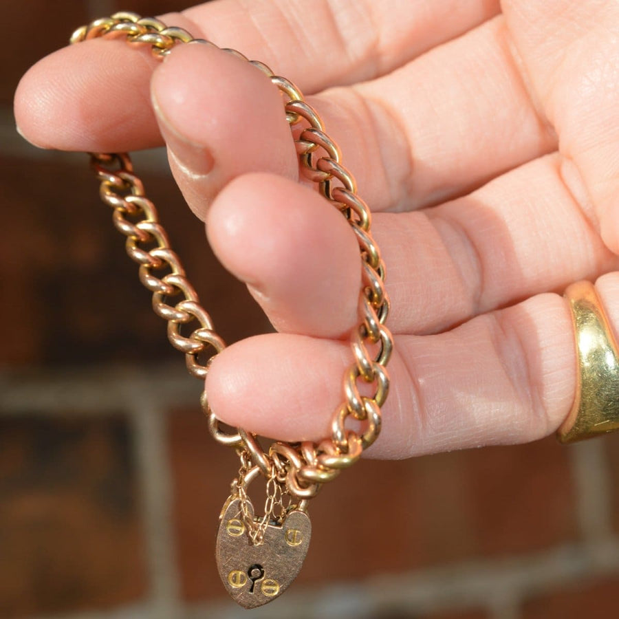 Small Edwardian 15ct gold child's curb bracelet featuring a heart lock, suitable for slender wrists.