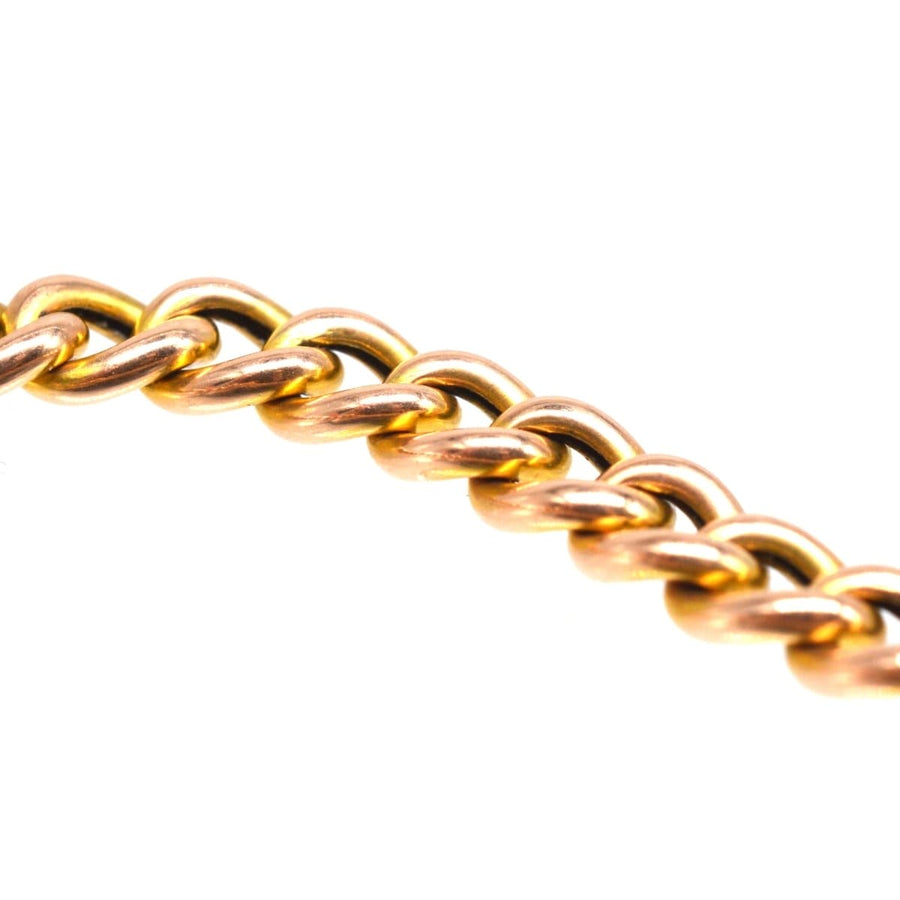 Close-up of a petite 15ct gold curb chain bracelet, showcasing its intricate links and warm hues.