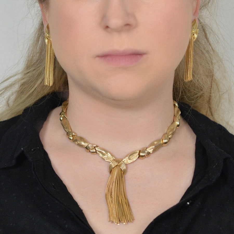 1950s Trifari gold-tone tassel necklace and earrings demi-parure set worn by a model.