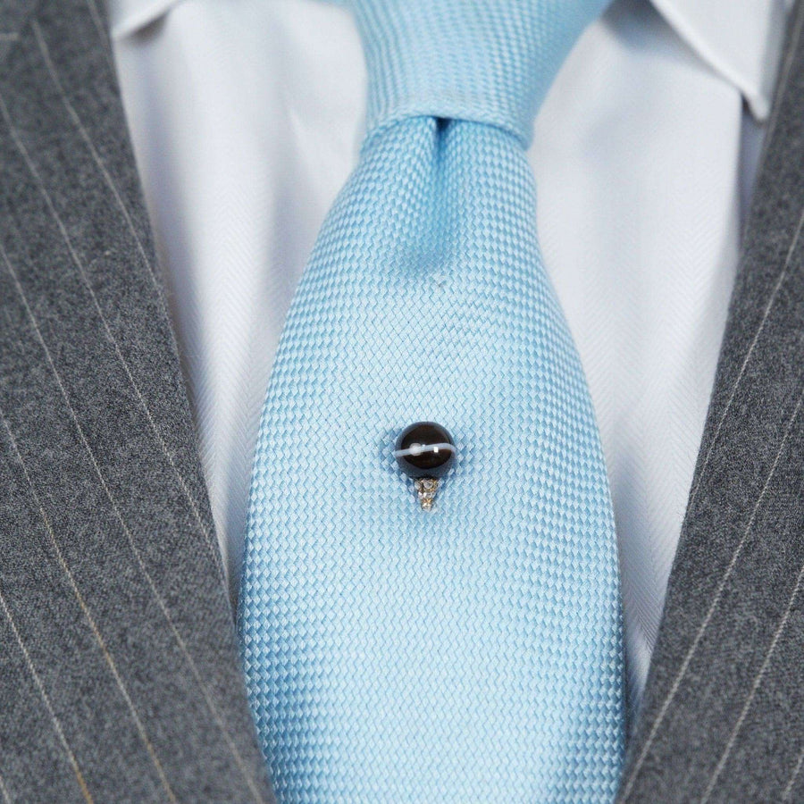 Victorian 15ct gold tie pin featuring a banded onyx sphere and diamond details on a light blue silk tie.