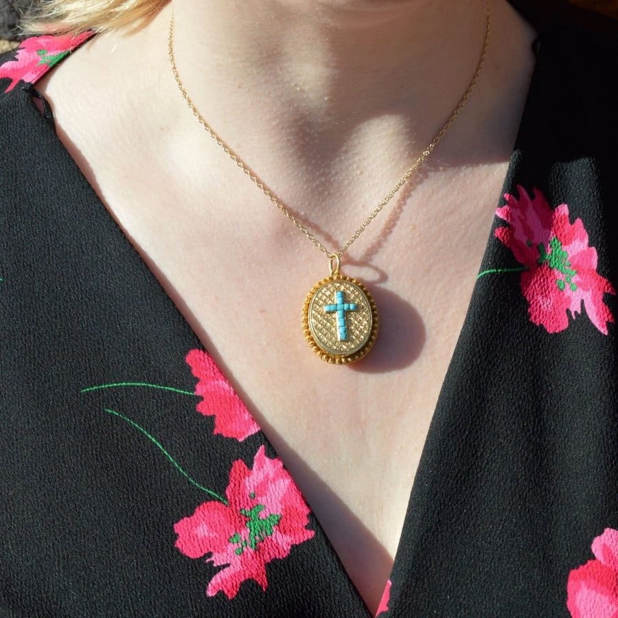 Victorian 18ct gold locket with turquoise cross worn as a necklace, showcasing its vintage beauty.