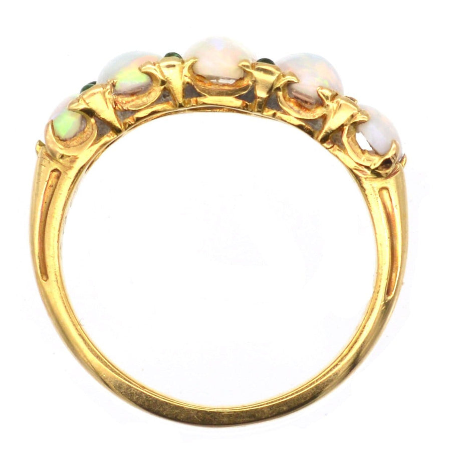Victorian 18ct gold ring featuring five opals and emerald accents, ideal for an engagement or special occasion.
