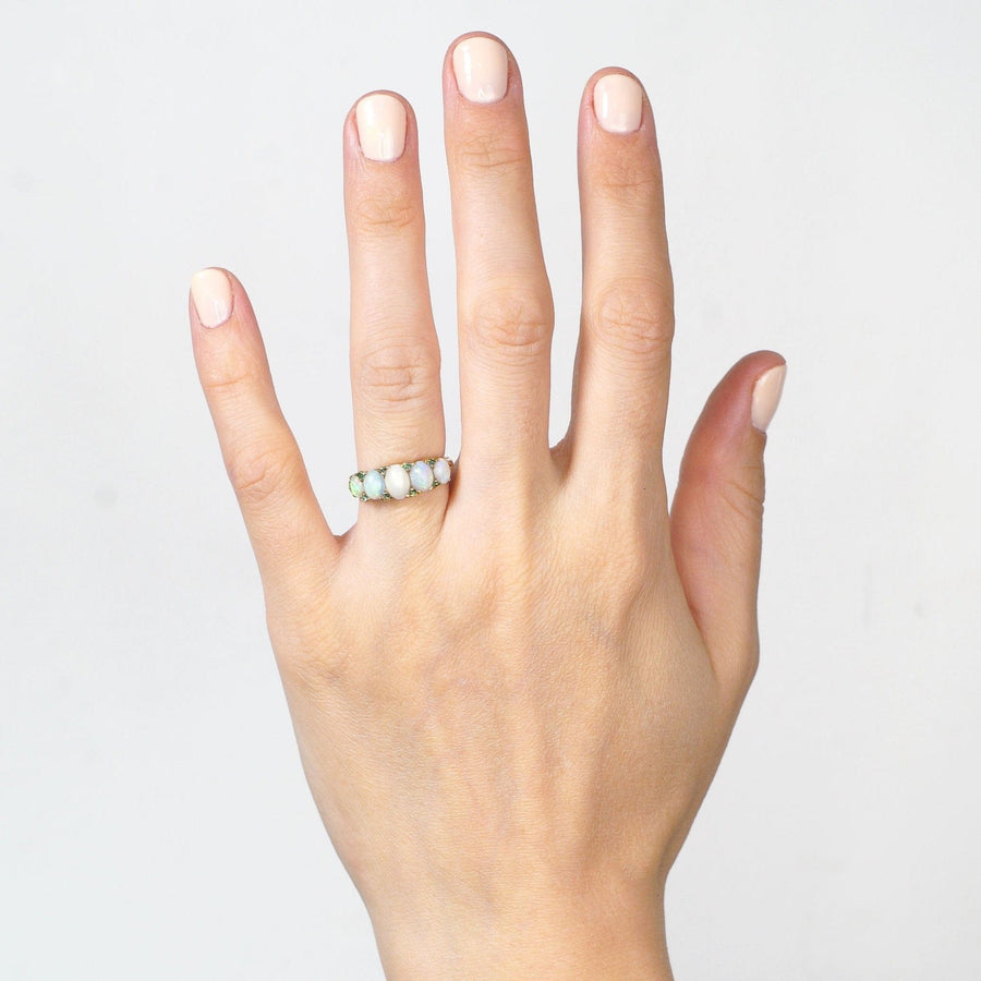 Victorian 18ct Gold ring with opals and emeralds worn on a hand, perfect for an engagement.