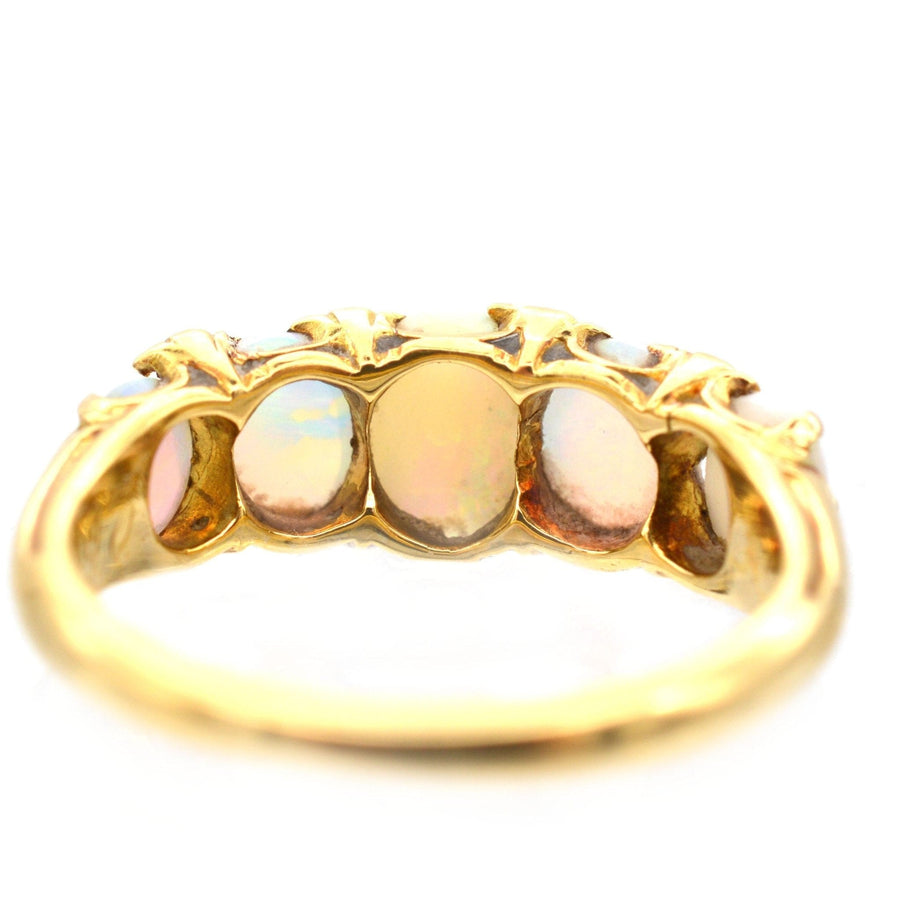 Victorian 18ct gold half hoop ring featuring five opals and emerald accents, perfect for an engagement.