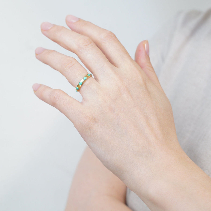 Victorian 18ct gold eternity ring with turquoise stones worn on hand, symbolizing love and December birthdays.