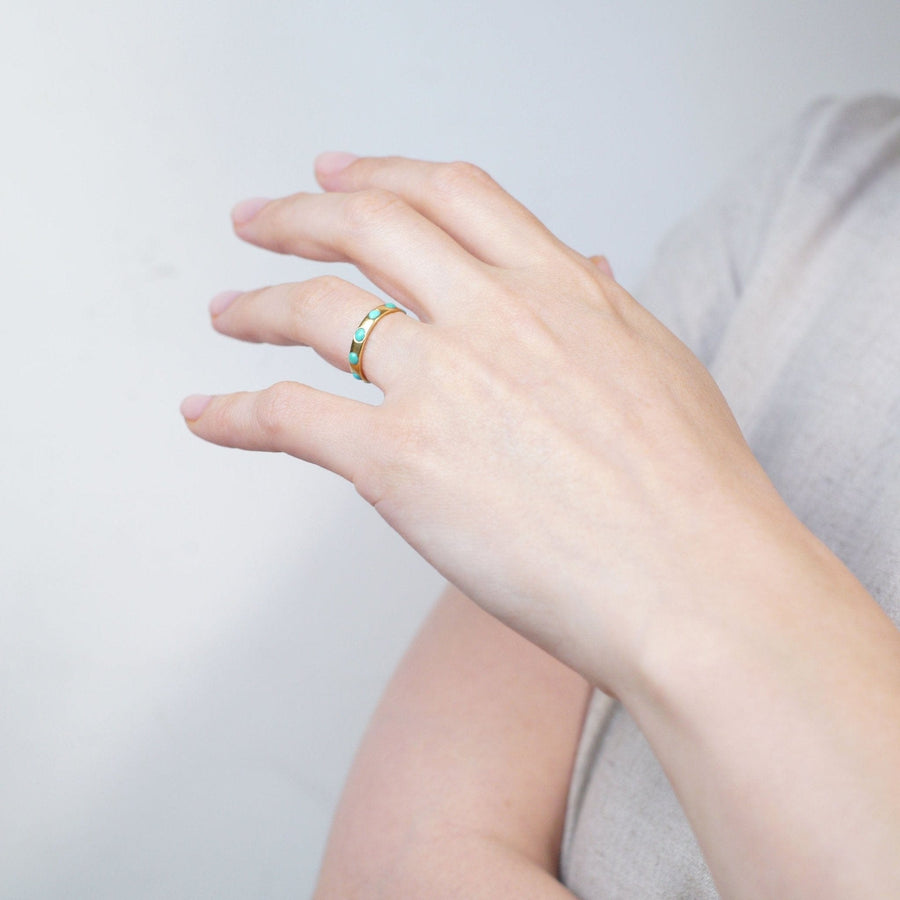 Victorian 18ct gold eternity ring with turquoise stones worn on a hand, showcasing its elegant design.