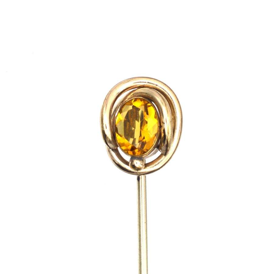 Victorian 9ct gold tie pin featuring a vibrant orange citrine paste in a swirling gold setting.