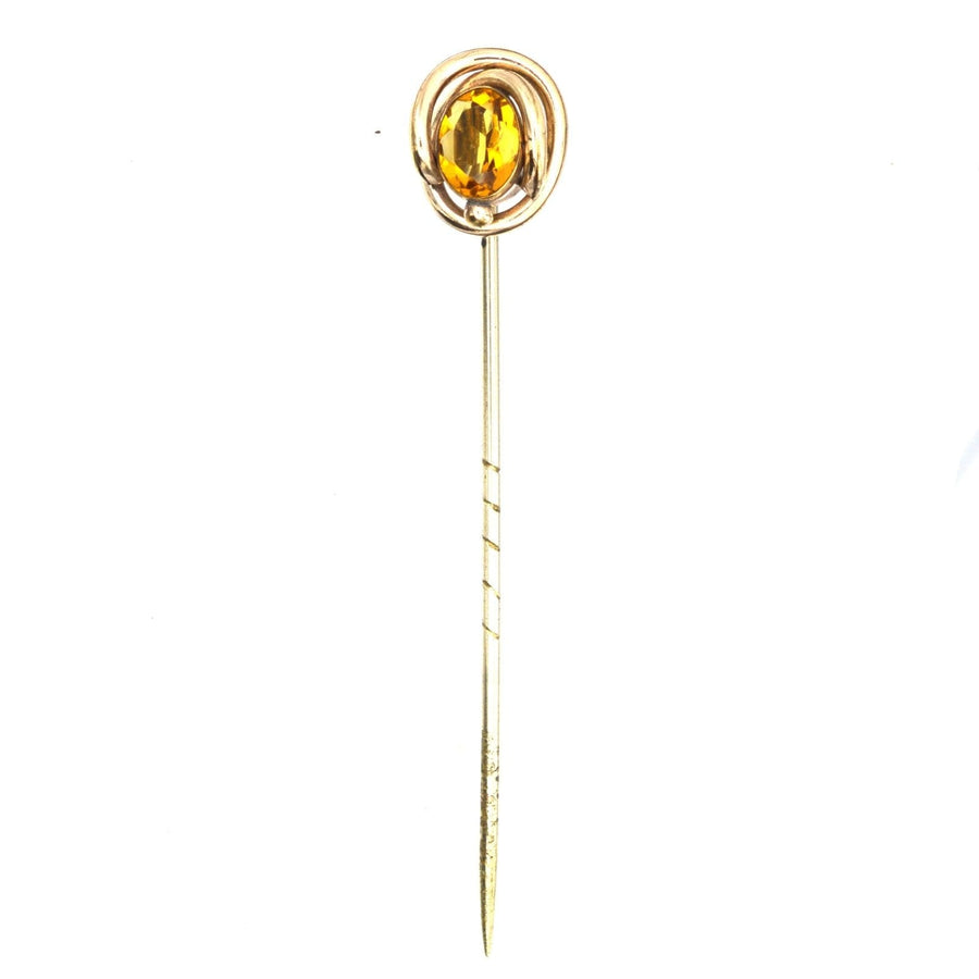 Victorian 9ct gold tie pin featuring a vibrant orange citrine paste surrounded by swirling gold.