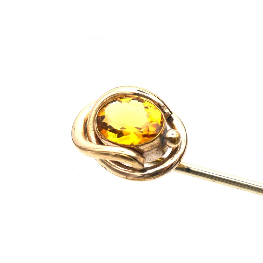 Victorian 9ct gold tie pin featuring a vibrant citrine paste stone in a golden swirl design.