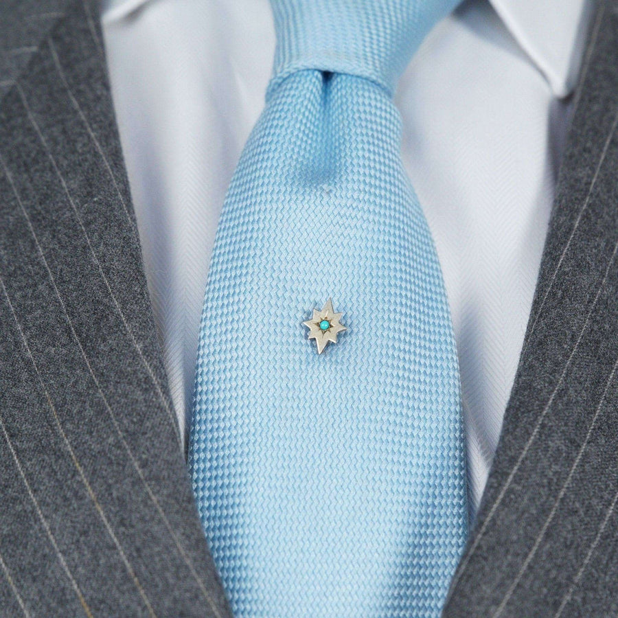 Victorian 9ct gold tie pin in the shape of a star with turquoise stone, styled on a light blue silk tie.