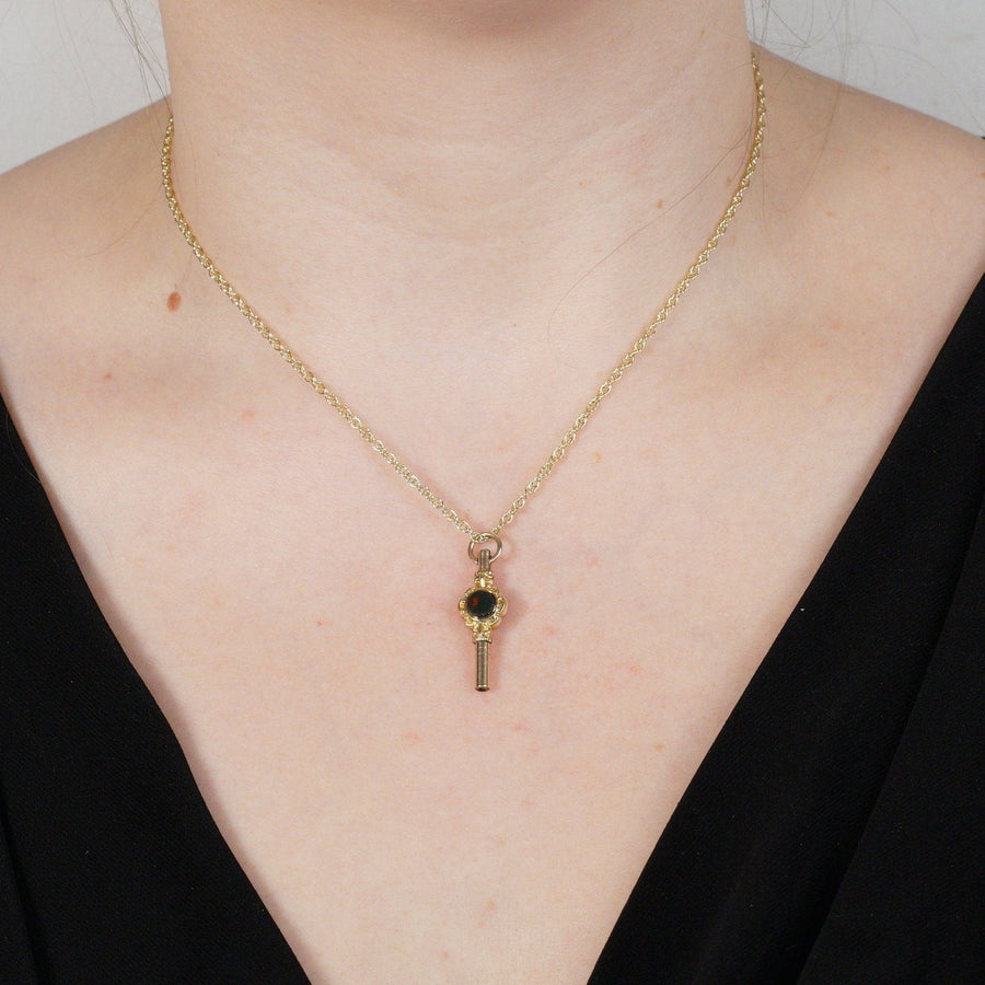 Victorian gold cased watch key pendant featuring bloodstone, worn on a model's neck.