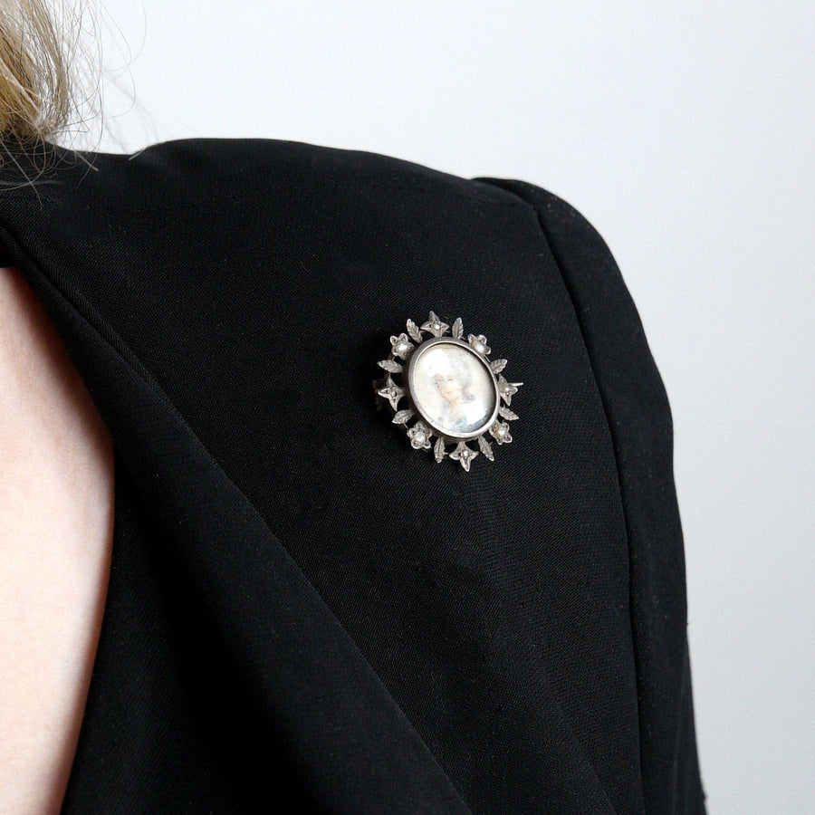 Victorian gilt brooch with a miniature portrait of a Georgian lady on a dark cloth jacket.