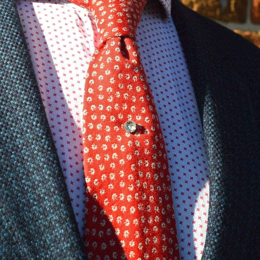 Victorian silver old mine cut paste tie pin on a patterned red tie with a stylish blazer.