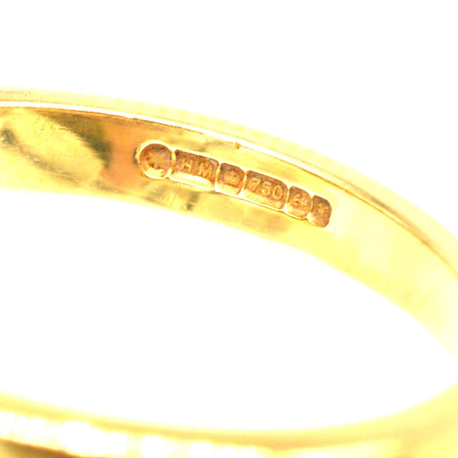 Close-up of hallmark showing 18ct gold stamp on a vintage ring, indicating quality and authenticity.