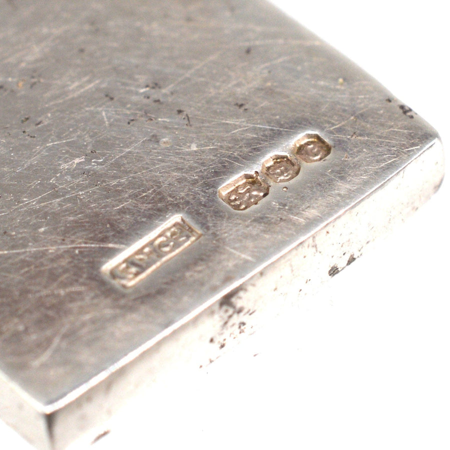 Close-up of vintage 1970s silver domino pendant showing hallmark details, made in London in 1977.