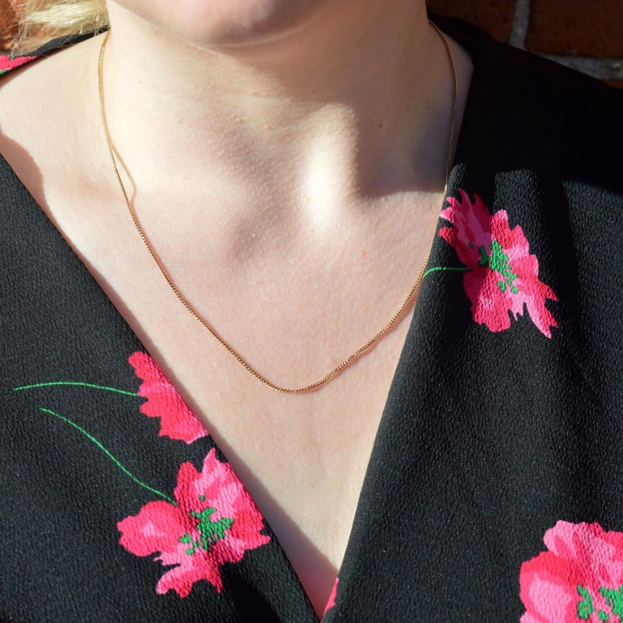 Model wearing a vintage 9ct gold flat curb chain by Cropp & Farr with floral dress