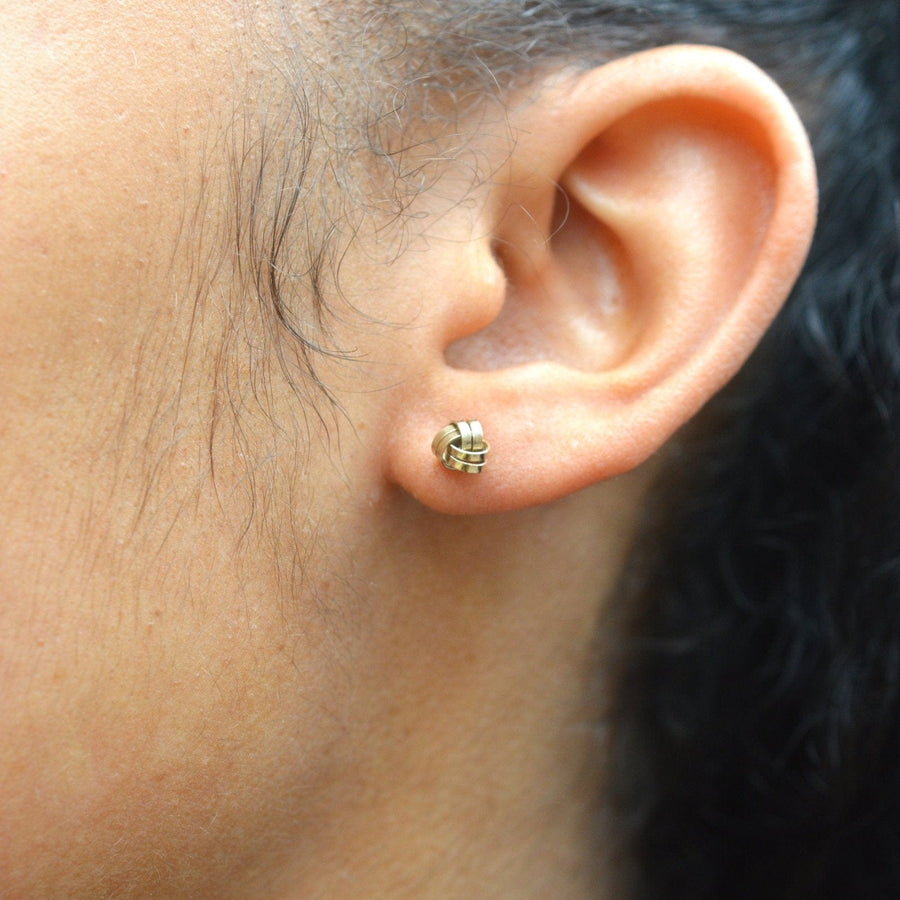 Vintage 9ct gold knot stud earrings worn on the ear, showcasing elegant and versatile design for day or evening.